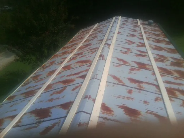 Rusted metal roof panels with new wood purlins before replacement — Storm Damage Roof Repair in Brookfield by Roofing Brothers
